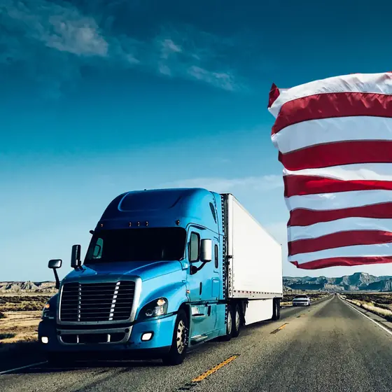 Tractor on a desert interstate with the American flag